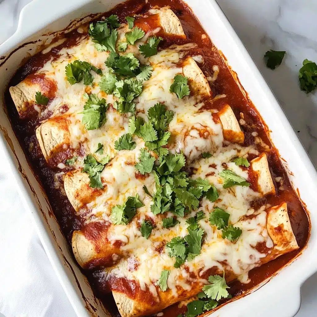 Beef Enchiladas, beef enchiladas recipe, Mexican beef enchiladas, homemade enchiladas, hearty beef enchiladas The image shows a baking dish filled with six rolled tortillas covered in a dark red sauce. On top of the tortillas is a layer of melted white cheese spreading over the sauce, with fresh bright green chopped cilantro sprinkled over the cheese. The dish is white and sits on a surface with a white marbled texture, next to a white cloth napkin. The edges of the tortillas are golden brown, showing slight toasting from baking.