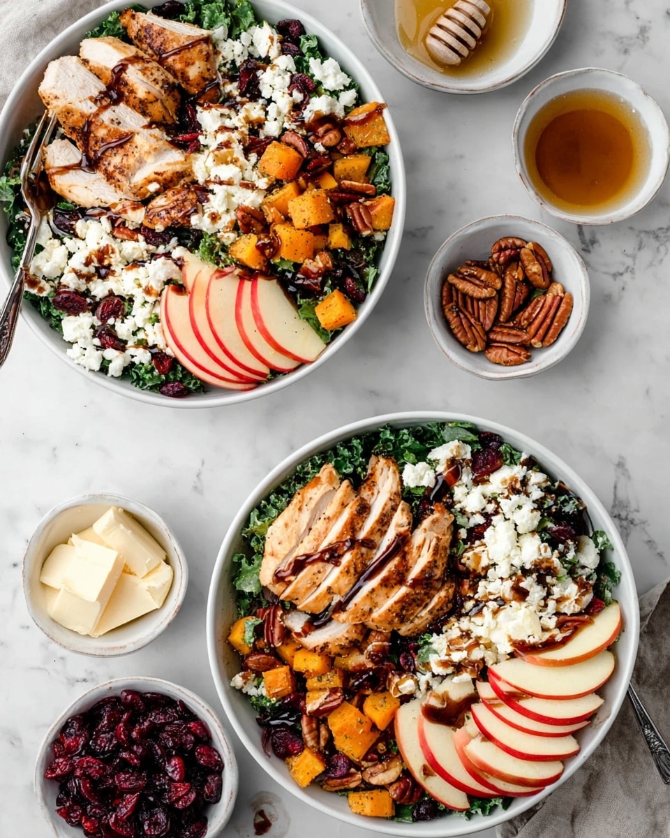 The image shows two white bowls filled with a colorful salad on a white marbled surface. Each bowl has a base layer of dark green kale leaves, topped with sliced red and yellow apples arranged on two sides. Grilled chicken slices with a light brown color sit on top, along with small golden cubes of roasted sweet potato. White crumbled cheese is scattered generously, mixed with dark red dried cranberries and light brown pecan nuts. A dark balsamic glaze is drizzled over the ingredients. A silver fork rests inside each bowl. Around the bowls are small white dishes holding extra cheese, pecans, dried cranberries, and honey with a honey dipper. Photo taken with an iphone --ar 4:5 --v 7