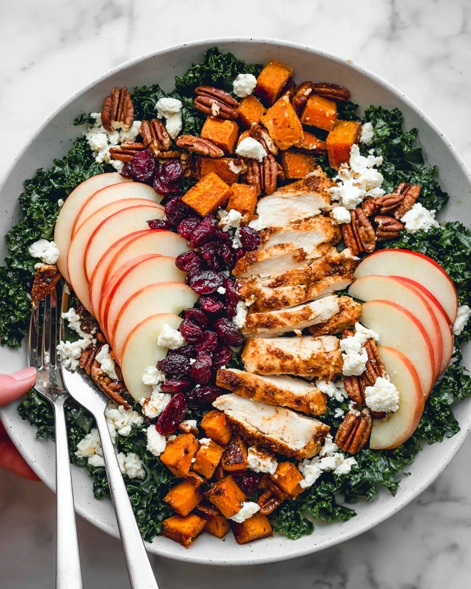 A white bowl sits on a white marbled surface filled with a salad made of three main layers: the bottom layer is dark green kale with a slightly wrinkled texture, the middle layer consists of golden-brown roasted sweet potato cubes scattered evenly, and the top layer features sliced grilled chicken with a golden-brown crust arranged in two groups on opposite sides. Apple slices with red skin and white flesh fan out in two clusters on the salad, while small clusters of deep red dried cranberries are scattered all over. Crunchy pecan halves and white crumbled cheese are sprinkled across the entire dish, adding texture and color contrast. A woman's hand holds a white fork and spoon on the left side of the bowl. Photo taken with an iphone --ar 4:5 --v 7