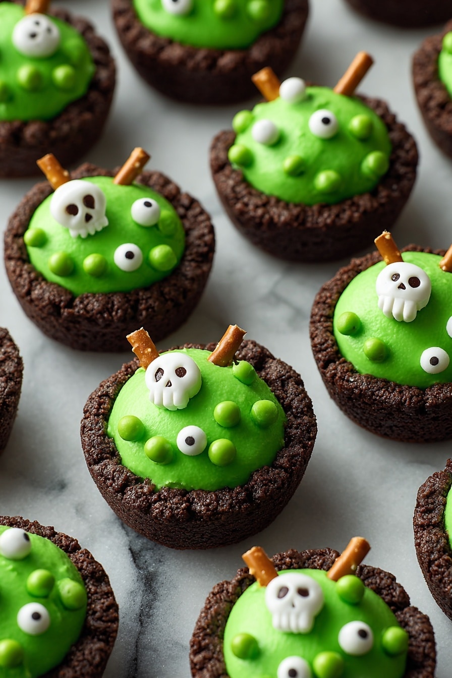 The image shows several dark brown cookie cups as the base layer, each with a thick, smooth, bright green frosting topped on them in a rounded mound shape. The green frosting is decorated with small white edible pearls, green candy balls, and white candy shapes like skulls and bones scattered across the surface. Some cookie cups have a single pretzel stick inserted vertically into the green frosting, adding a crunchy texture. All items are placed on a black tray with a close-up focus, and the background is a white marbled texture. photo taken with an iphone --ar 2:3 --v 7 - Cauldron Cookie Cups, Halloween Cookie Cups, Spooky Cookie Desserts, Edible Witch Cauldrons, Festive Halloween Treats