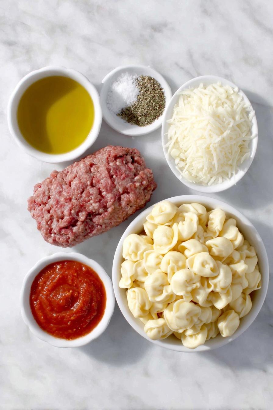 Flat lay of a small white ceramic bowl of golden olive oil, a handful of fresh lean ground beef, a small white ceramic bowl with diced white onion, three peeled garlic cloves, a small white ceramic bowl of crushed bright red tomatoes, a small white ceramic bowl of smooth red tomato sauce, a small white ceramic bowl containing dried Italian seasoning herbs, a small white ceramic bowl of kosher salt crystals, a small white ceramic bowl of freshly ground black pepper, a generous mound of fresh cheese tortellini pasta, and a small white ceramic bowl heaped with freshly grated mozzarella cheese, all arranged in perfect symmetry on a clean white marble surface, soft natural light, photo taken with an iPhone, professional food photography style, fresh ingredients, white ceramic bowls, no bottles, no duplicates, no utensils, no packaging --ar 2:3 --v 7 --p m7354615311229779997 - Baked Tortellini with Tomato and Mozzarella, baked tortellini recipe, cheesy baked pasta, Italian tortellini casserole, comforting pasta bake