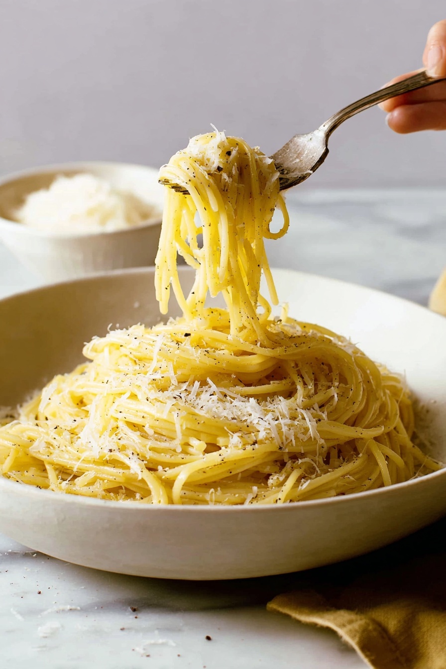 A white, shallow bowl filled with a pile of yellowish spaghetti pasta, sprinkled with small patches of grated white cheese and black pepper. The pasta strands have a smooth and slightly shiny texture, twisted around a silver fork that a woman's hand is lifting from the bowl. The background and surface around the bowl have a white marbled texture, with a blurred white bowl of grated cheese in the back left side. The scene is softly lit, showing a warm and cozy feel. photo taken with an iphone --ar 2:3 --v 7 - Creamy Cacio e Pepe Pasta, how to make Cacio e Pepe, easy Italian pasta recipes, quick creamy pasta dishes, traditional Roman pasta