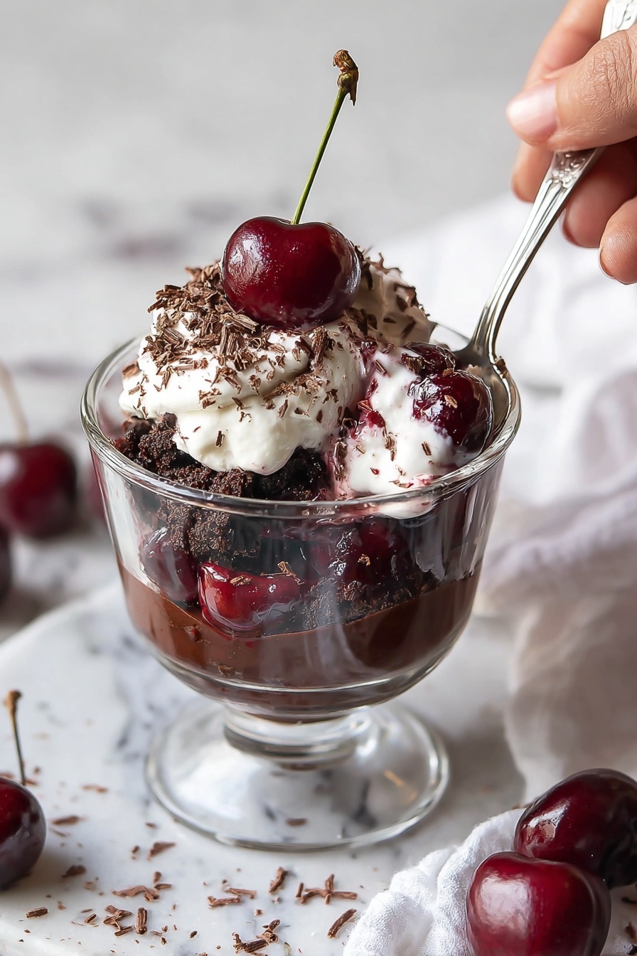 A glass trifle dish holds a layered dessert starting with a dark chocolate crumb base at the bottom, followed by a thick chocolate pudding layer. Above this is a white cream layer with swirls of red cherry sauce, then another dark chocolate crumb layer, and a second thick chocolate pudding layer. The top is covered with glossy cherry sauce and a generous layer of fluffy white whipped cream sprinkled with tiny chocolate shavings. Several fresh cherries with green stems sit on top, adding a shiny red contrast. The dish is on a white marbled surface with a small white bowl of chocolate shavings nearby, photo taken with an iphone --ar 2:3 --v 7 - Black Forest Cherry Trifle, Black Forest dessert, cherry trifle recipe, chocolate cherry dessert, layered trifle sweet