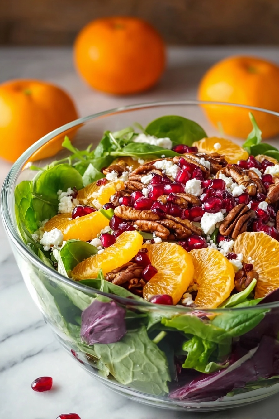 A clear glass bowl is filled with a colorful layered salad. The bottom layer is fresh green spinach and mixed greens with some purple leaves scattered in. On top, bright orange mandarin slices are placed evenly, along with deep red pomegranate seeds scattered around. There are also brown pecan halves spread throughout. Small white crumbles of cheese are sprinkled over the top, adding contrast. The bowl sits on a white marbled surface with two whole mandarins blurred softly in the background. The image has a natural light setting, highlighting the fresh and vibrant colors of the salad. Photo taken with an iphone --ar 2:3 --v 7 - Festive Citrus Salad with Feta and Pomegranate, holiday citrus salad, winter fruit salad, easy holiday salad, fresh citrus and pomegranate salad