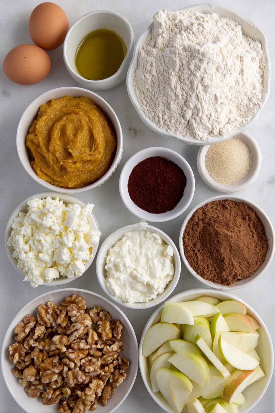 Flat lay of fresh all purpose flour in a small mound, a few brown eggs with smooth uncracked shells, a glistening golden olive oil pool in a small white ceramic bowl, vibrant orange pumpkin puree in a small white bowl, creamy white ricotta cheese dollop in a small white bowl, finely grated pale parmesan cheese in a small white bowl, rustic brown sugar crystals in a small white bowl, ground cinnamon and allspice powders gently mounded side by side, bright red cayenne powder in a small white bowl, lightly cracked black pepper powder, a handful of fresh bright green sage leaves, diced Gala apple pieces showing red and cream hues in a small white bowl, small white bowl with pale apple cider vinegar, chopped walnuts with rough textured surface in a small white bowl, fresh uncooked sheet of pale ravioli dough laid flat with clean edges — no utensils or packaging, all ingredients arranged with perfect symmetry on a clean white marble surface, soft natural light, photo taken with an iPhone, professional food photography style, fresh ingredients, white ceramic bowls, no bottles, no duplicates, no utensils, no packaging --ar 2:3 --v 7 --p m7354615311229779997 - Pumpkin Ravioli with Apple Sage Butter Sauce, Pumpkin Ravioli Recipe, Fall Pasta Dish, Homemade Pumpkin Ravioli, Apple Sage Butter Sauce