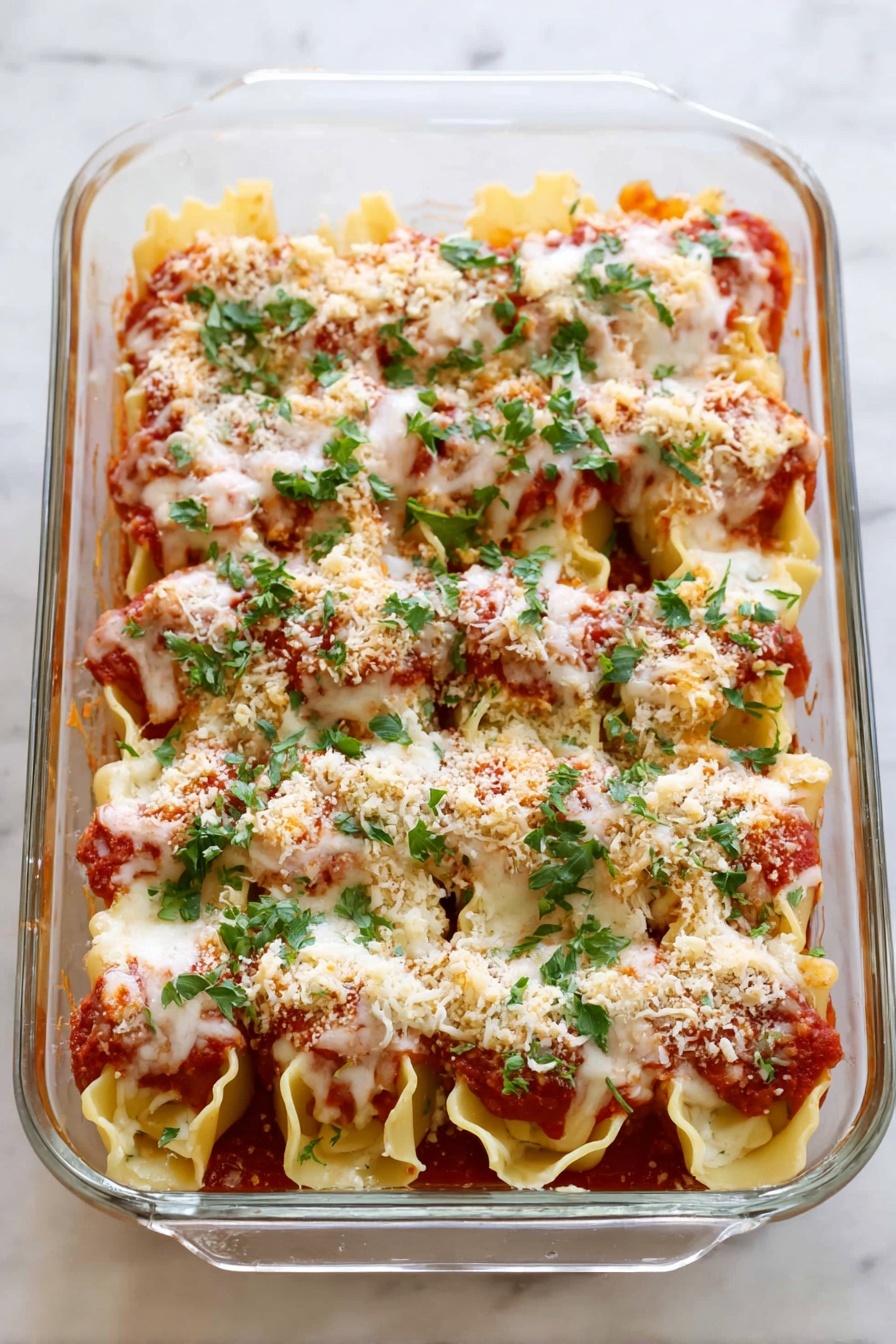 Three large pasta shells are arranged on a white plate with tomato sauce spread beneath them. Each shell is filled with a white cheese filling, topped with a layer of melted cheese that looks soft and lightly browned. A sprinkle of light brown breadcrumbs sits on top of the melted cheese, and fresh green parsley leaves are scattered over and around the shells, adding a bright touch. The plate rests on a white marbled surface. photo taken with an iphone --ar 2:3 --v 7 - Chicken Parmesan Stuffed Shells, stuffed pasta shells with chicken and cheese, cheesy baked stuffed shells, Italian stuffed shells recipe, family-friendly chicken pasta dish