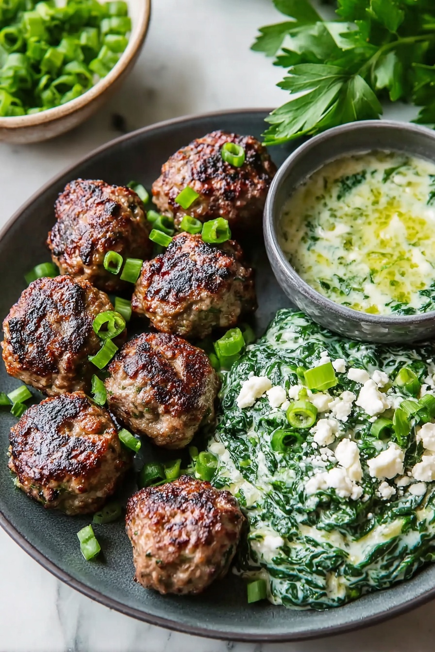The image shows a dark gray plate with seven browned meatballs placed on the left side. On the right side of the plate, there is a creamy spinach mixture topped with chopped green onions and small white crumbles, likely cheese. Behind the plate, there is a small gray bowl filled with a greenish sauce that includes white chunks. Fresh green parsley leaves are visible in the background. The surface under the plate is a white marbled texture. photo taken with an iphone --ar 2:3 --v 7 - Spicy Lamb Meatballs Green Herb Dip, spicy lamb meatball recipe, lamb meatball appetizer, flavorful lamb meatballs with herb dip, easy lamb meatball ideas