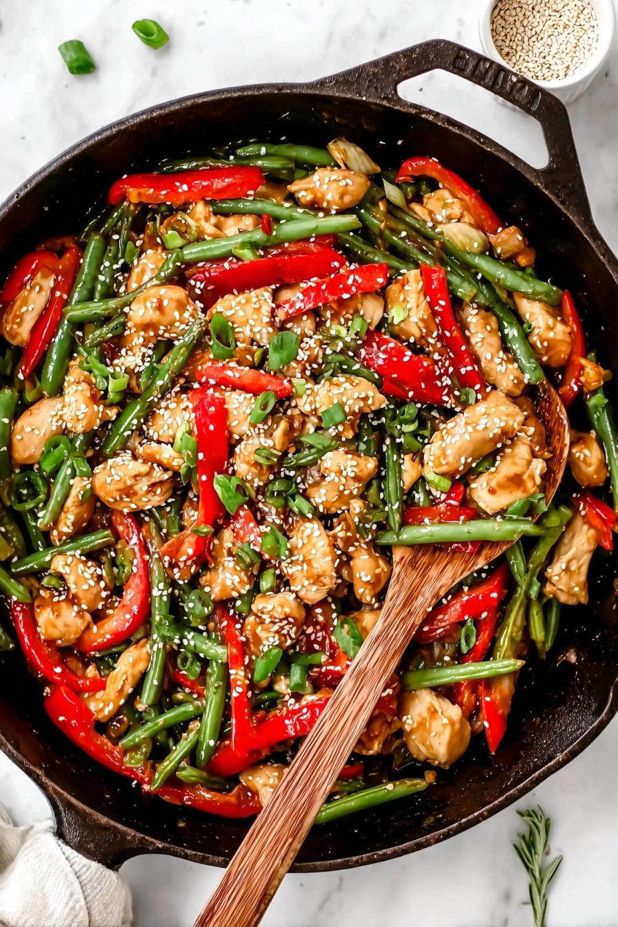 A black cast iron pan filled with a colorful stir-fry showing three main layers: the base layer has shiny, green beans with a fresh texture spread all around; the middle layer has bright red sliced bell pepper strips adding a pop of color mixed evenly; the top layer contains chunks of light brown cooked chicken pieces sprinkled with white sesame seeds and chopped green onions, giving it a fresh and textured look. On the right side, a wooden spoon with a natural grain rests inside the pan, partly covered by the food. The whole scene is set on a white marbled surface with a small white bowl of sesame seeds and a green herb sprig partially visible. Photo taken with an iphone --ar 2:3 --v 7 - Healthy Orange Chicken Stir Fry with Cauliflower Rice, healthy stir fry recipes, low-carb orange chicken, quick healthy dinner ideas, colorful vegetable stir fry