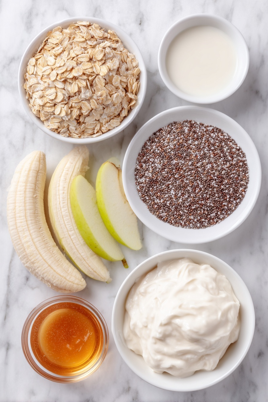 Flat lay of a small heap of rolled oats, a small white bowl filled with tiny black and white chia seeds, a small white bowl containing warm brown chai spice powder, a dollop of thick plain Greek yogurt on a simple white ceramic plate, a small white bowl of creamy milk, a small white bowl with amber-colored pure maple syrup, a few whole unpeeled bananas sliced lengthwise resting on a simple white ceramic plate, a few crisp green apple slices arranged neatly on a white dish, and a small heap of golden-brown granola, all placed on a clean white marble surface, soft natural light, photo taken with an iPhone, professional food photography style, fresh ingredients, white ceramic bowls, no bottles, no duplicates, no utensils, no packaging --ar 2:3 --v 7 --p m7354615311229779997 - Chai Spiced Overnight Oats, healthy chai oats, cozy breakfast recipes, nutritious overnight oats, easy breakfast ideas
